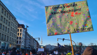 Schild vor blauem Himmel bei einer Demonstration: Ohne Vielfalt kein Reichtum